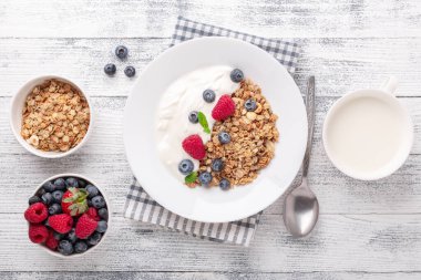 Fırında granola ve Yunan yoğurdu ile sağlıklı bir kahvaltı. Çeşitli taze böğürtlenler