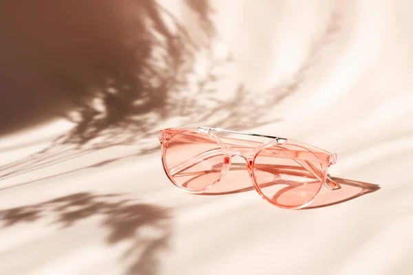 Modne różowe okulary przeciwsłoneczne na tle kwiatów. Pampas trawa naturalne cienie na beżowym tle. Koncepcja akcesoriów letnich — Zdjęcie stockowe