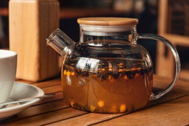 Kafedeki cam çaydanlıkta deniz dikenli çay. Sağlıklı ve lezzetli deniz dikenli çay.