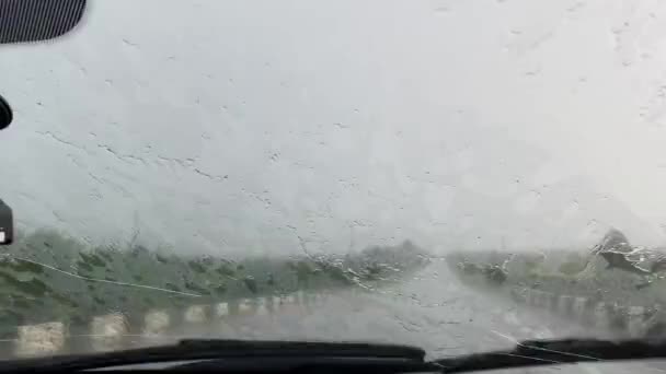 Windschutzscheibe eines vom Regen nassen Autos, Wischerblätter reinigen die Frontscheibe — Stockvideo