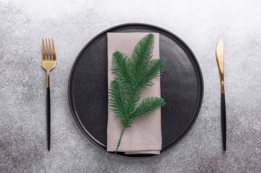 Siyah seramik tabak, peçete, çatal bıçak seti ve taştan arka planda. Üst Manzara. Boşluğu kopyala