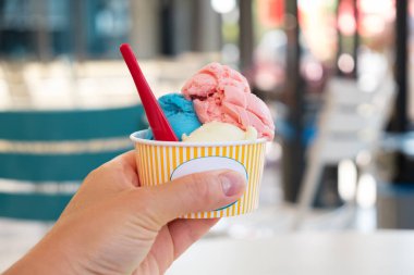 Bulanık bir sokak yemeğinin üzerinde dondurmalı kağıt bardak. Seçici Odaklanma.