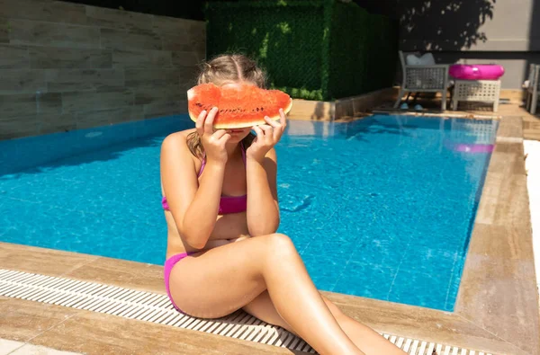 Kleine süße Mädchen mit Wassermelone amüsieren sich am Pool. Sommerreise Hotelurlaub — Stockfoto