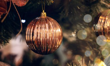 Noel ağacının dalında altın bir noel balosu. Bokeh etkisi. Metnin için kopyalama alanı olan tebrik kartı