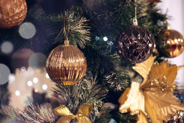 Altın toplar ve parlak ışıklarla süslenmiş Noel ağacı dalı. Noel, kış, yeni yıl konsepti