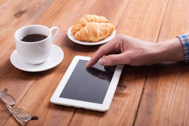 Adam dijital tablet kruvasan ve kahve