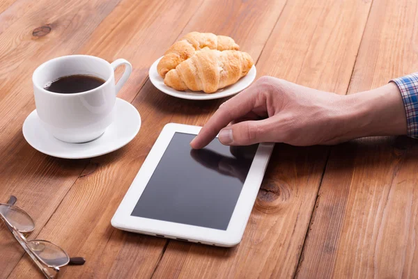 Homem com croissants tablet digital e café — Fotografia de Stock
