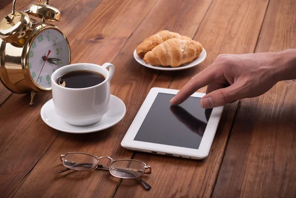 Hand of man with tablet computer on the kitchen table at dinner. — Stock Photo, Image