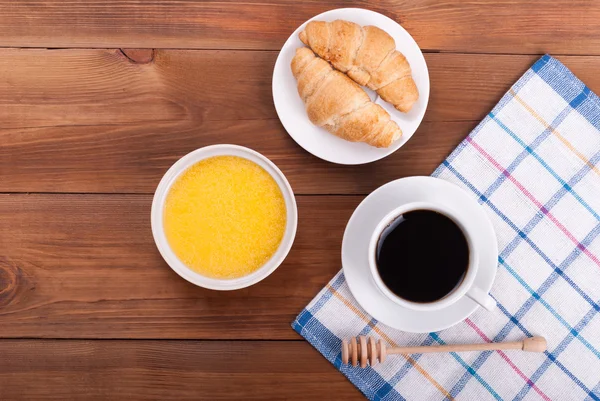 Xícara de café e croissants mel cristalizado na mesa da cozinha . — Fotografia de Stock