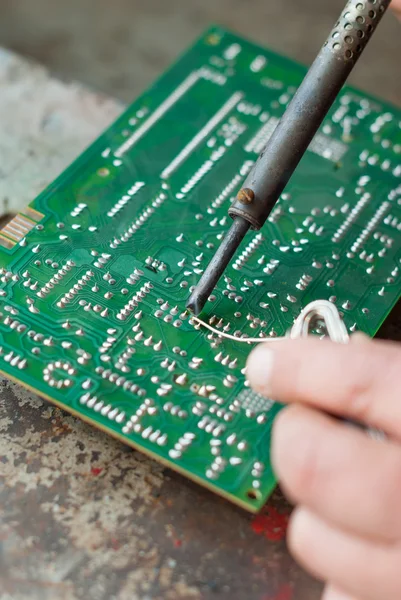 Man met soldeerbout om te solderen van elektronisch bestuur. — Stockfoto