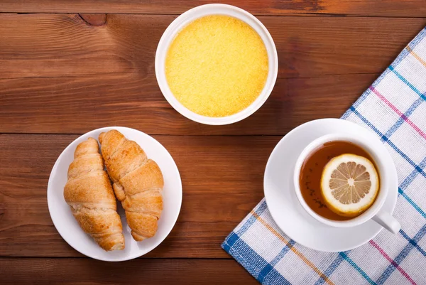 Chá com croissants de limão e mel em uma mesa de cozinha . — Fotografia de Stock