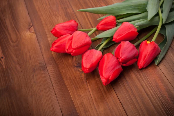 Tulipanes rojos sobre un fondo de madera. —  Fotos de Stock