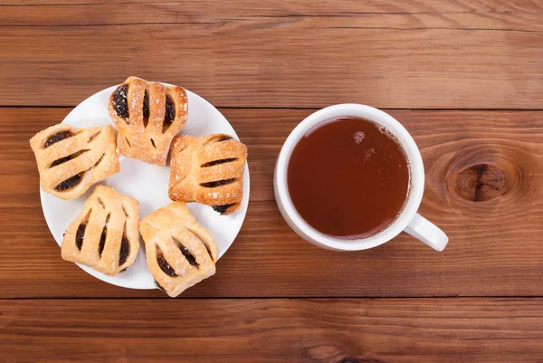 Chá e biscoitos doces em uma mesa de madeira . — Fotografia de Stock