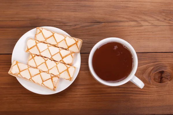 Taza de té y galletas en un plato sobre la mesa . — Foto de Stock