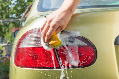Yakın çekim bir adamın arabasını yıkama.