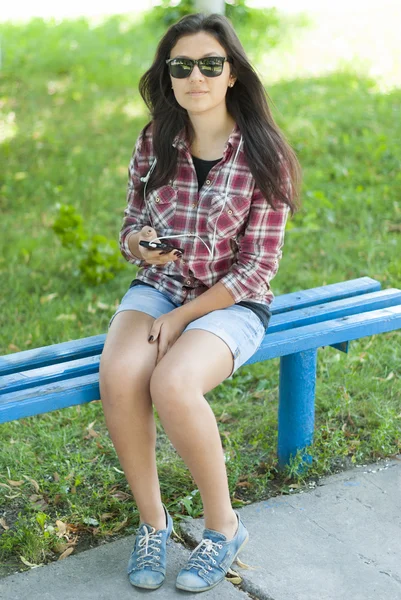 Girl with mobile phone on the street in the park. — Stock Photo, Image