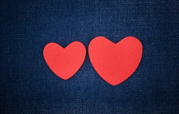 Red hearts on the jeans. — Stock Photo, Image