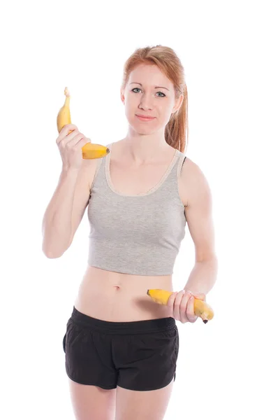 Chica atlética con plátanos en la mano sobre fondo blanco . — Foto de Stock