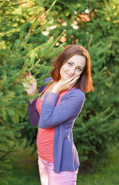 Retrato de uma menina em um parque perto de uma árvore de Natal . — Fotografia de Stock