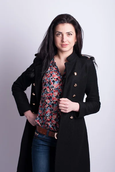 Beautiful brunette in a black coat. — Stock Photo, Image