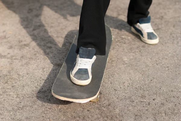 Ragazzo su uno skateboard sneakers . — Foto Stock