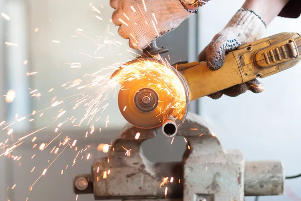 Homem corta um tubo de metal . — Fotografia de Stock