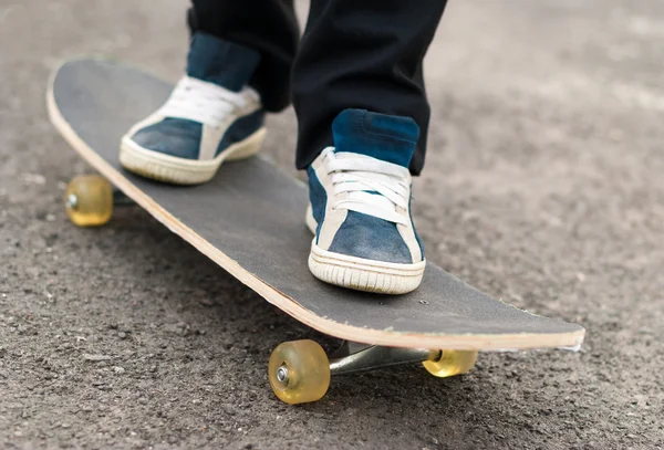 Skateboarder rides on a skateboard feet in sneakers. — Stock Photo, Image