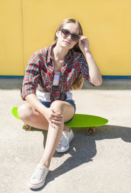 Şık genç kız açık havada rahatlatıcı kaykay eğlenceli ile.