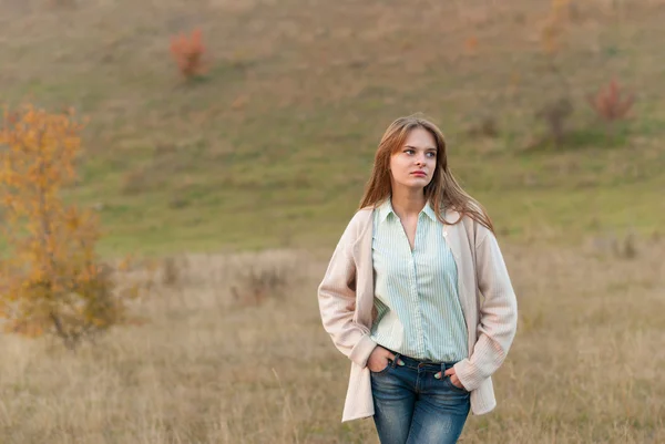 Jeune belle fille debout dans une prairie . — Photo