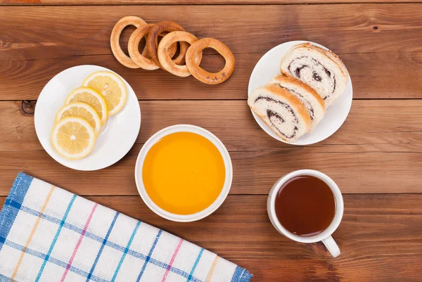 Xícara de chá com mel, produtos de confeitaria e geléia na mesa . — Fotografia de Stock