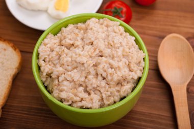 Ahşap masa üzerinde bir kase yulaf ezmesi.