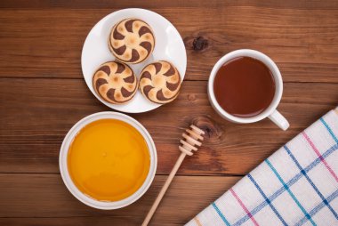 Fincan çay tatlım kurabiye ahşap bir masa üzerinde.