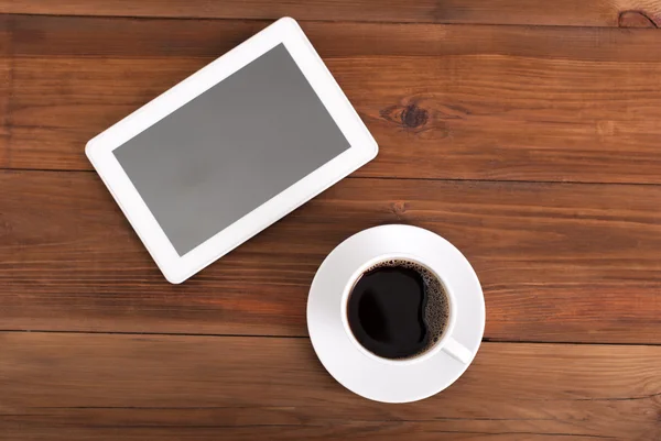 Xícara de café e tablet na mesa. Vista superior  . — Fotografia de Stock
