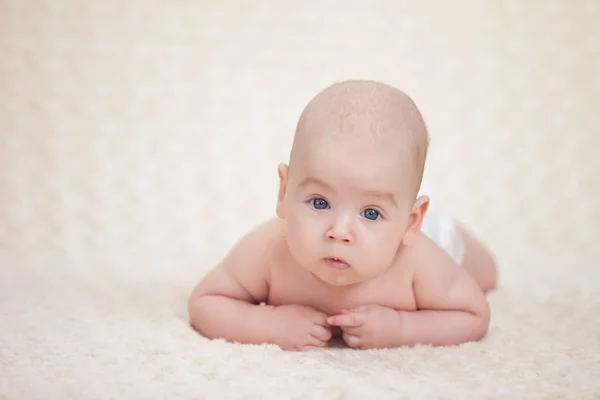 Infant baby lying on a soft bed cover — Stock Photo, Image