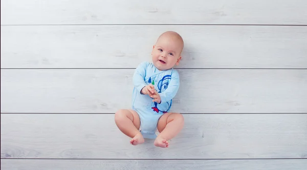 赤ちゃん、寄木細工の床の上に横たわる — ストック写真