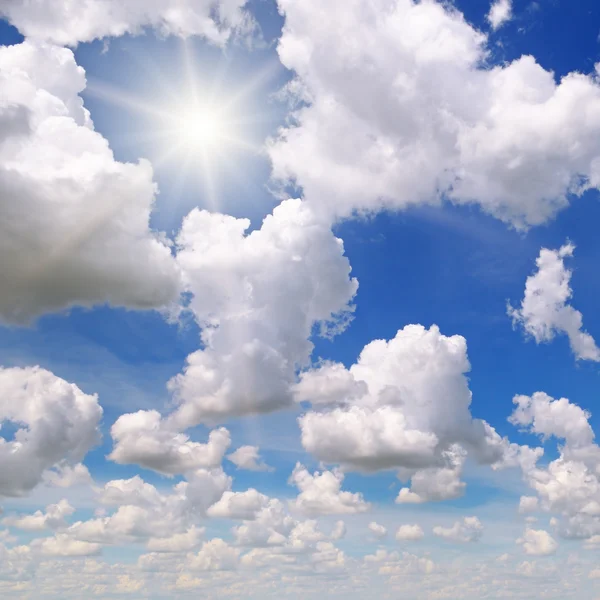 Sun on blue sky with white clouds — Stock Photo, Image