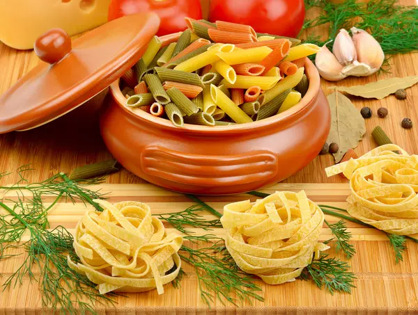 Pasta, cheese and spices on the board — Stock Photo, Image