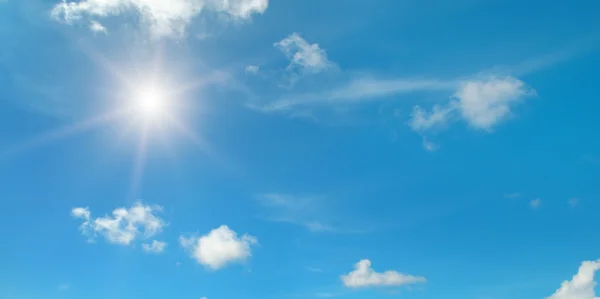 Sun on blue sky with white clouds — Stock Photo, Image