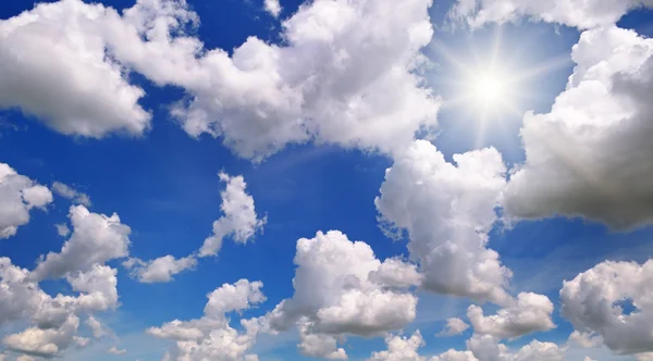 Sun on blue sky with white clouds — Stock Photo, Image