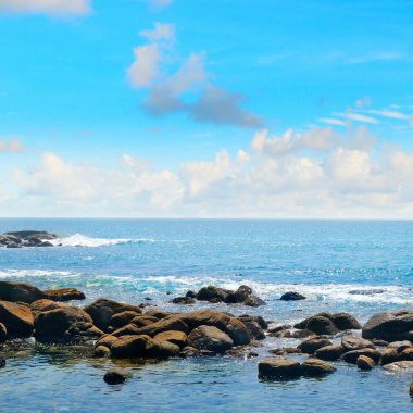 Tropikal plajda ve mavi denizde Rock Stone.