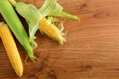Kırsal ahşap masadaki koçanlarda taze mısır. Metin için boş alan.