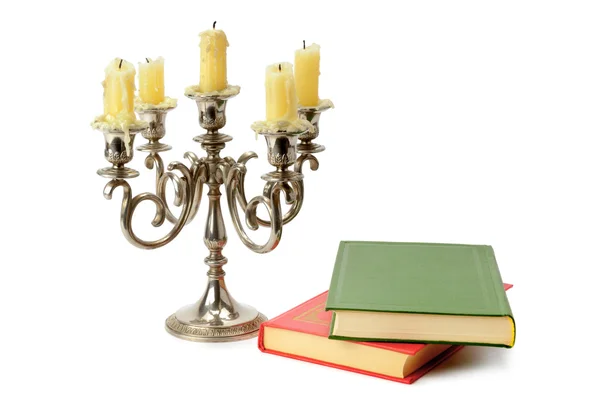 Candeliere e libri isolati su sfondo bianco — Foto Stock