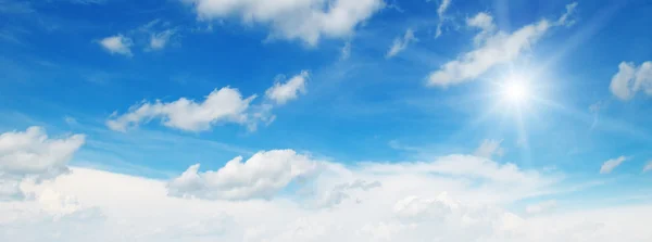 Sun on blue sky with white clouds — Stock Photo, Image