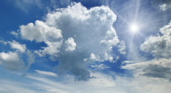 Słońce na błękitnym niebie z białymi chmurami — Zdjęcie stockowe