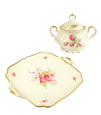 İçinde antika bir porselen şeker kasesi ve altın kaplamalı istiridye tabağı bulunan büyüleyici bir stüdyo. Zarif porselenler zarif pembe çiçek ve kuş motifleriyle süslenir. Lüks ve gelenek duygusu taşır.