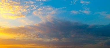 Çarpıcı, dramatik bir gökyüzü, gün batımının ya da bulutların üzerinde gün doğumunun canlı ve zıt renklerini yakalar. Doğal mavi ve altın gradyan, geniş bir kopya alanına sahip güzel, atmosferik bir arkaplan sunar..