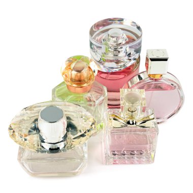 Beyaz arka planda çeşitli şekil ve boyutlarda, temiz, pembe ve yeşil sıvı içeren çeşitli cam parfüm şişeleri koleksiyonu sergilenmektedir. Bu izole hayat güzellik, lüks ve zarafeti kozmetik ve parfüm temalarına taşır..