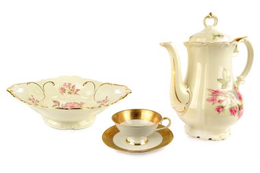 Antika porselen bir kompozisyonda uzun bir kahve demliği, sığ bir meyve kasesi ve altın yaldızlı çay fincanı ve çay tabağı bulunur. Bu zarif, yüksek-tuşlu kesim, geleneği, lüksü ve güzel yemeği taşır.