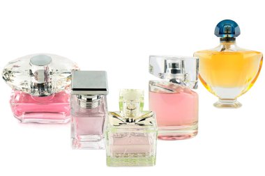 Pembe, sarı ve kehribar tonlarında sıvılar içeren beş zarif cam parfüm şişesinin bir koleksiyonu temiz beyaz bir arkaplanda sergilenmektedir. Bu resim lüks, güzellik, koku ve sofistike kişisel bakım kavramlarını aktarır..
