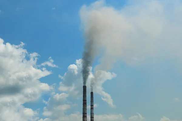 Fumaça dos canos contra o céu azul — Fotografia de Stock
